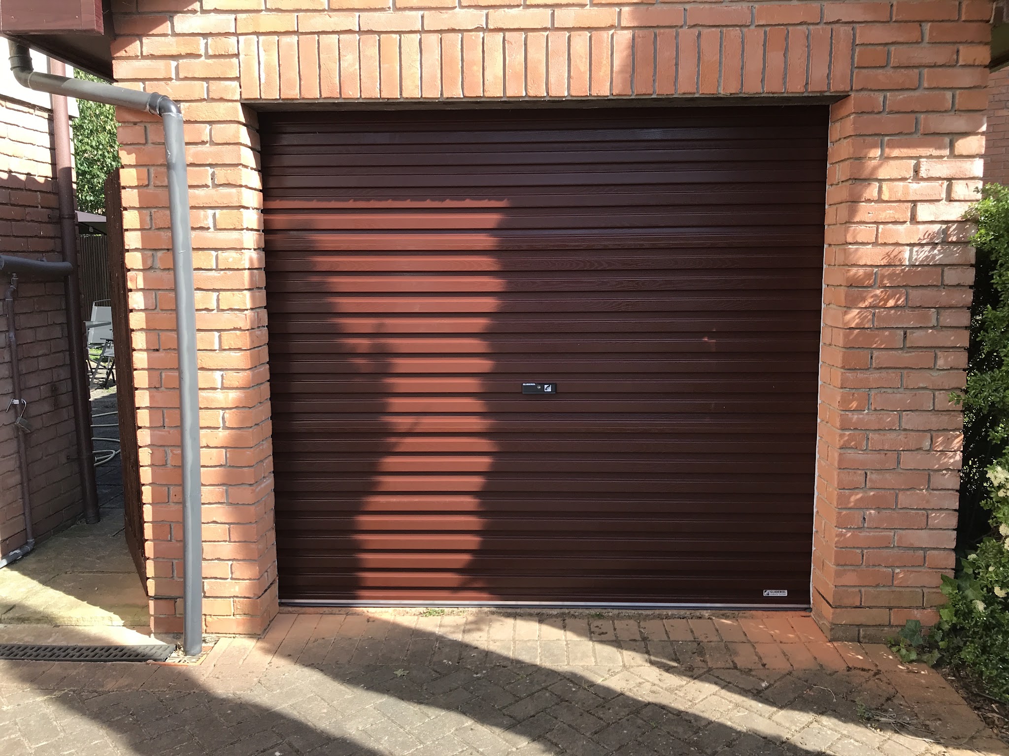 Brown roller garage door in a brick garage