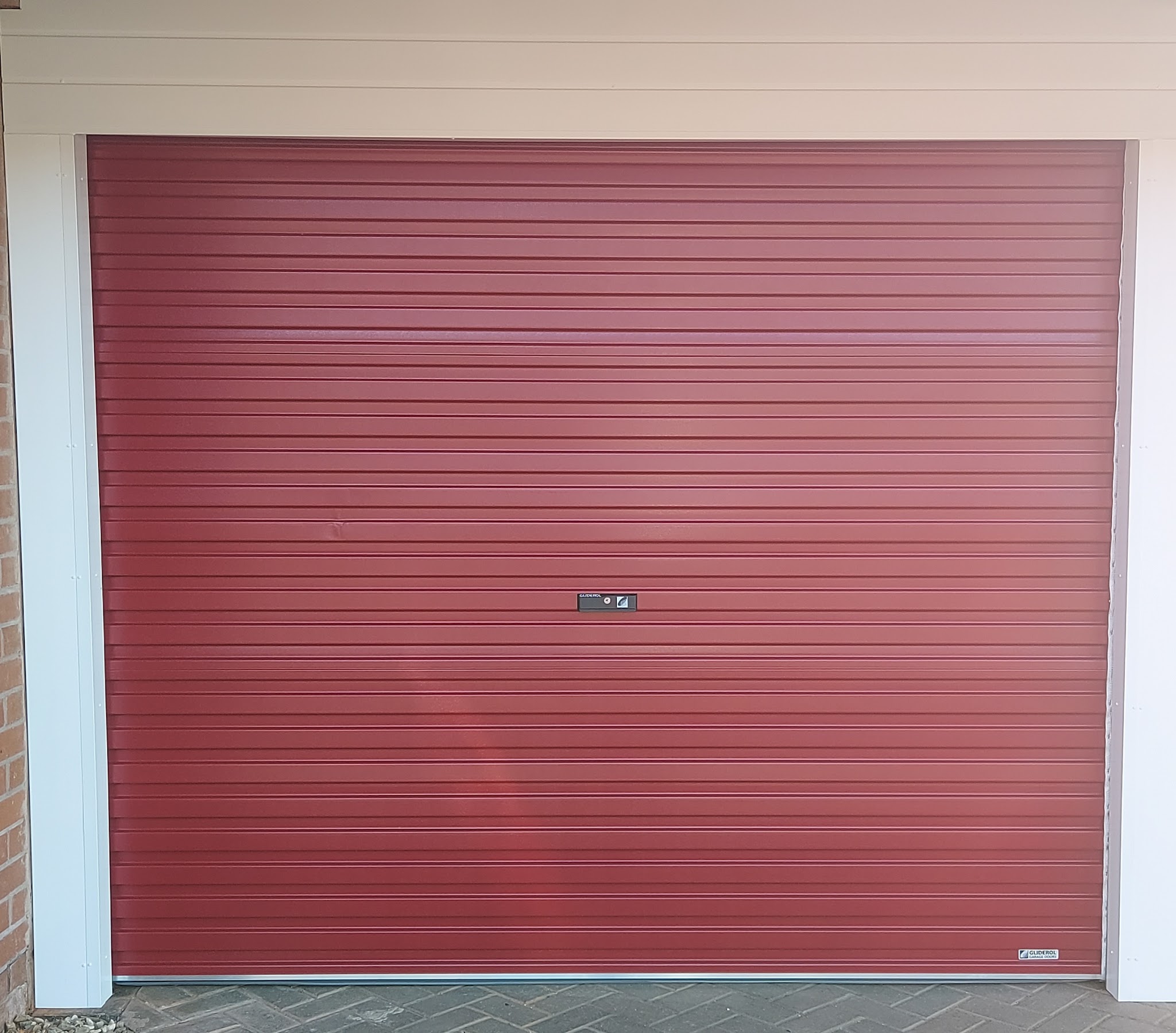 Red roller garage door with white surround