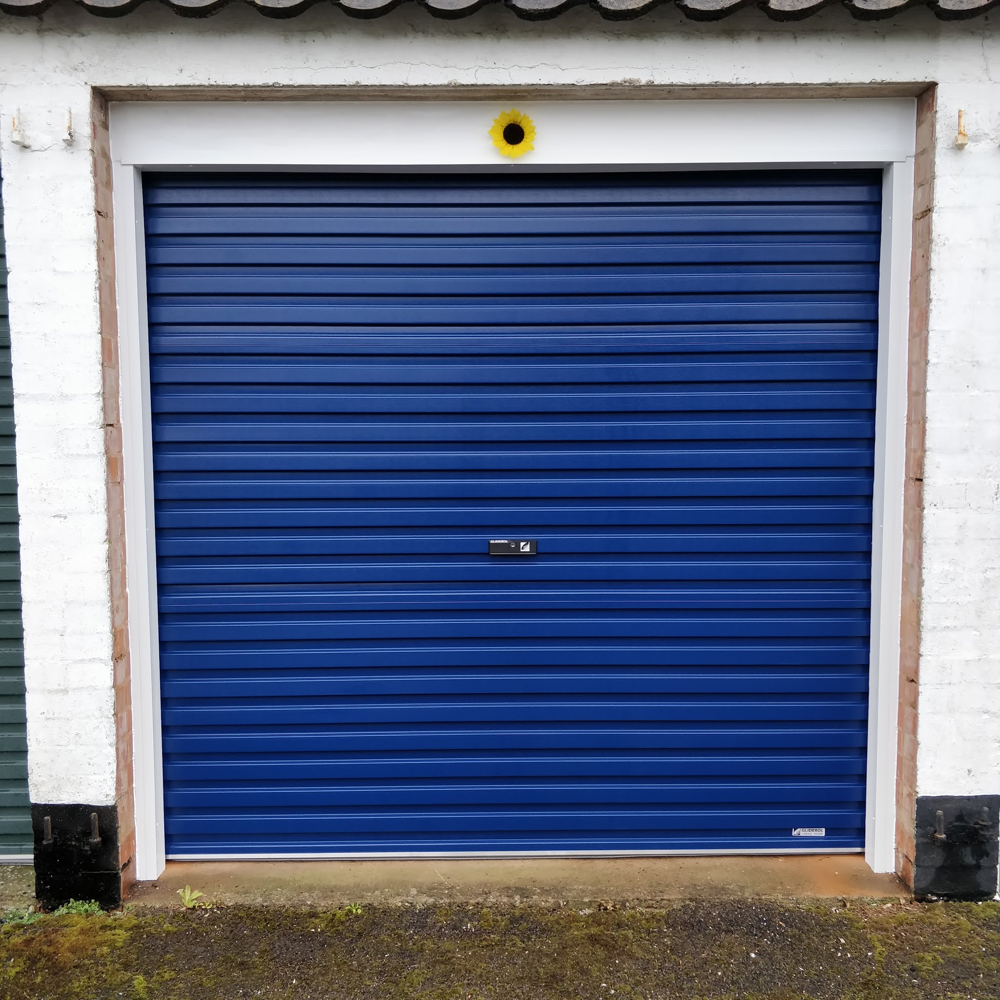 Blue roller garage door in a white painted garage
